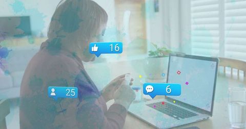 Mature woman using laptop with digital notifications at cozy home office