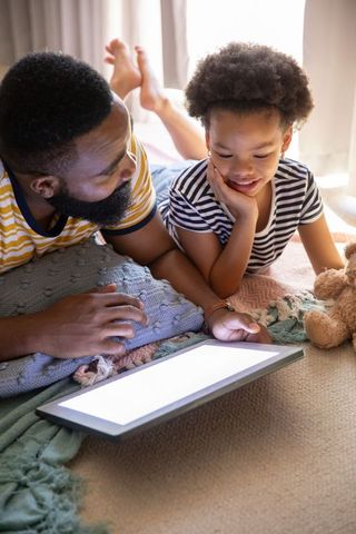 Father and Daughter Bonding with Tablet on Cozy Carpeted Floor