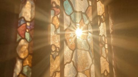 Sunlight streaming through colorful stained glass panels