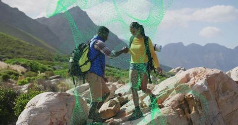 Hiking Partners Crossing Rocky Terrain in Mountain Valley