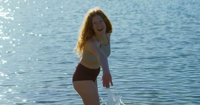 Joyful Woman Playing in Clear Blue Water on Sunny Day - Download Free Stock Images Pikwizard.com