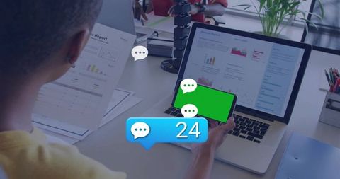 Professional checking phone and analyzing reports on laptop with 24 chat notifications