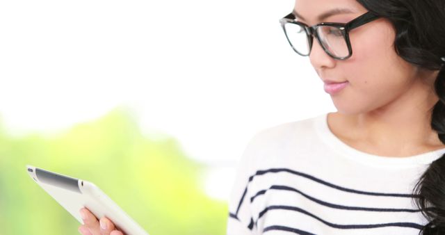 Young Asian Woman Reading Digital Tablet Under Natural Light - Download Free Stock Images Pikwizard.com