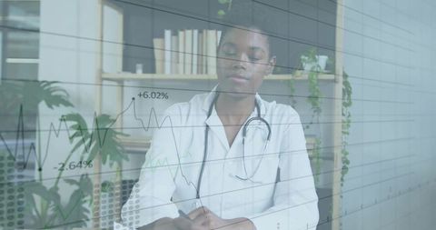 Doctor writing patient notes with transparent data chart overlay in clinic