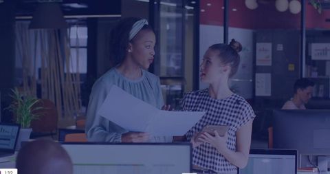 Women Discussing Plans in Modern Open Office Reviewing Documents and Tablet