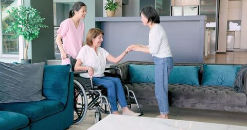 Empowered Senior Woman in Wheelchair with Nurse and Friend