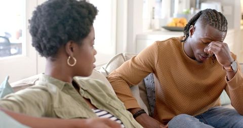 Thoughtful Couple Sharing Sofa Time in Modern Home