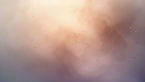 Glowing pastel bokeh with fine dust on frosted glass, lit warm hazy abstract backdrop