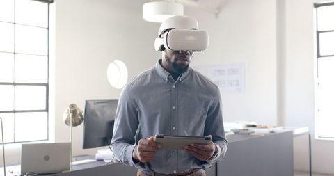 Businessman Engages with VR Headset and Tablet in Modern Office