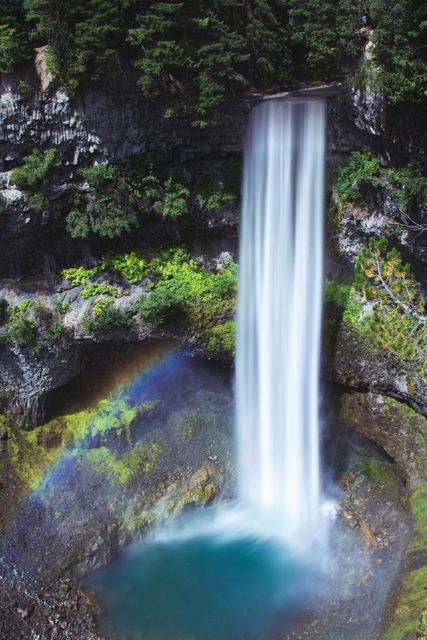 Stunning Waterfall Flowing with Visible Rainbow and Lush Greenery - Download Free Stock Photos Pikwizard.com
