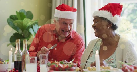 Festive Diverse Senior Couple Laughing at Christmas Dinner Table