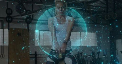 Woman swinging kettlebell in gym with holographic globe overlay for fitness technology