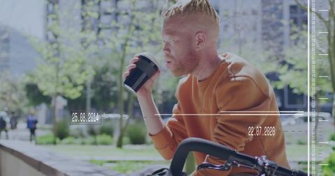 Urban Cyclist Enjoying Coffee Break in Park Plaza