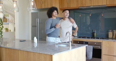 Diverse Male Partners Enjoying Morning Coffee in Bright Kitchen