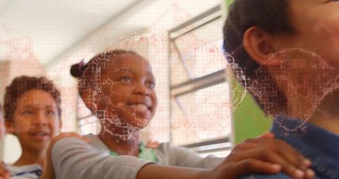 Smiling girl placing hands on classmate's shoulders with subtle world map overlay