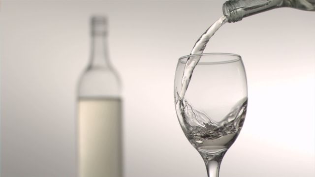 The video captures white wine being poured into a glass in slow motion, showcasing detail and clarity. Ideal for advertising beverage products, wine tasting events, bars or restaurants. Can be used in articles related to wine appreciation, lifestyle, or sophisticated dining experiences.