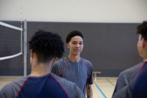 African american teens preparing for volleyball match in school gym showing team focus
