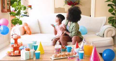 Family Celebrating Son's Birthday with Cake and Decorations at Home