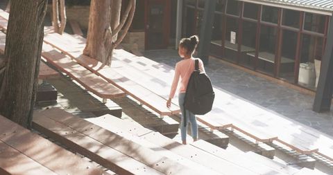 Student walking through modern campus courtyard