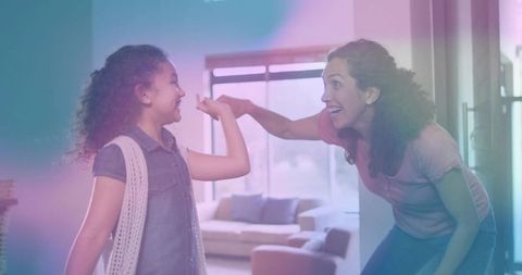 Mother and Daughter Sharing High-Five at Home Entryway