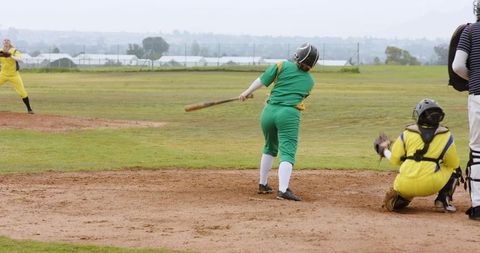 Female softball players competing on grass field