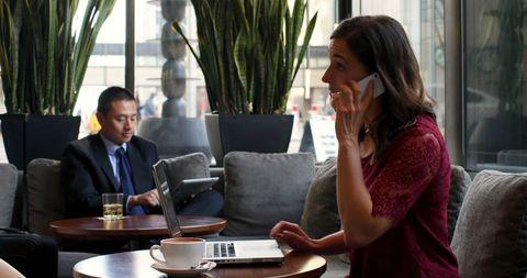 Businesswoman Engaged in Work Call at Hotel Lounge