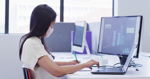 Businesswoman Analyzing Data on Computer During Pandemic
