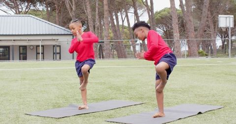 Children Practicing Yoga Outdoors on Turf Field