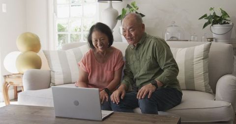 Seniors video chatting on laptop, happy home connection moment