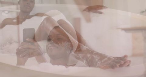 Woman Relaxing in Bubble Bath While Using Smartphone