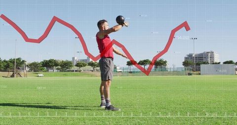 Athlete lifting kettlebell on sports field with data analytics overlay, performance graph
