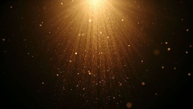 Golden dust beams streaming downward through warm spotlight with sparkling bokeh