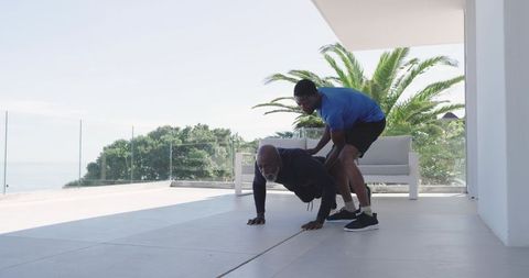 Personal trainer coaching client on terrace with ocean view