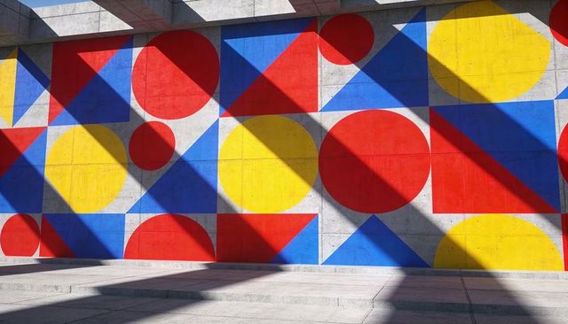 Vibrant geometric mural on concrete plaza wall with bold primary shapes and diagonal shadows