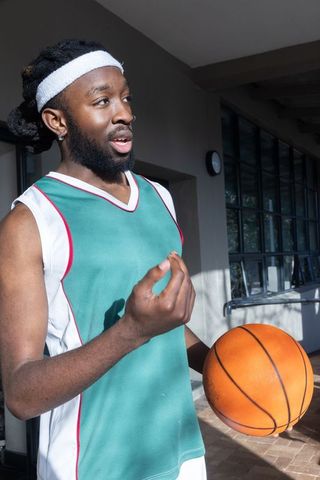 Urban Basketball Athlete in Dynamic Pose Under Covered Walkway