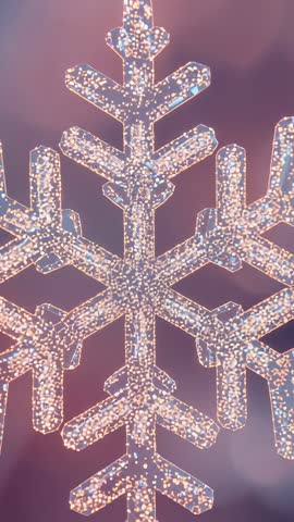 Vertical video showing glowing snowflake ornament pulsing LED glitter while camera zooming in