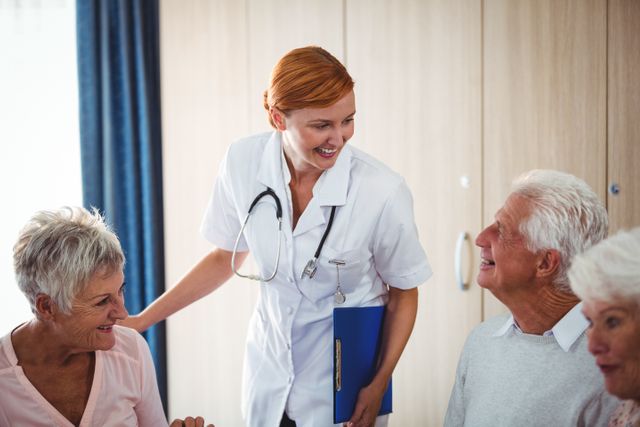 Smiling Nurse Interacting with Seniors During Breakfast in Retirement Home - Download Free Stock Photos Pikwizard.com