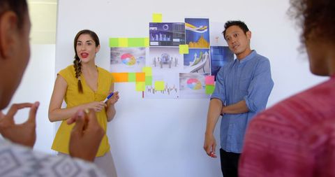 Diverse Team Engaging in Business Presentation with Charts and Sticky Notes