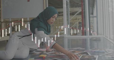 Designer in Studio with Hijab Arranging Photos Amongst Data