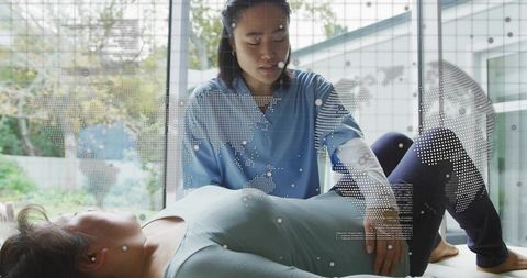 Female Clinician Examining Patient Abdominal Health with Digital Global Data Overlay