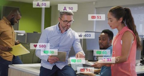 Collaborative team analyzing social media metrics on tablet and laptop in modern open office