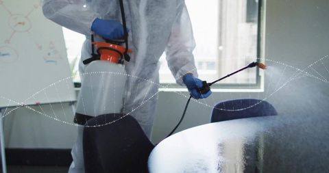 Disinfecting conference table in office protective suit sprayer ppe sanitation cleanup