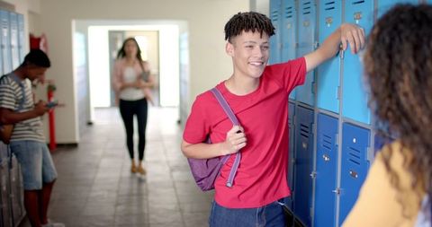 High School Teens Socializing by Lockers in Hallway