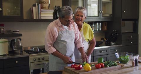 Smiling Senior Couple Cooking Together in Modern Kitchen