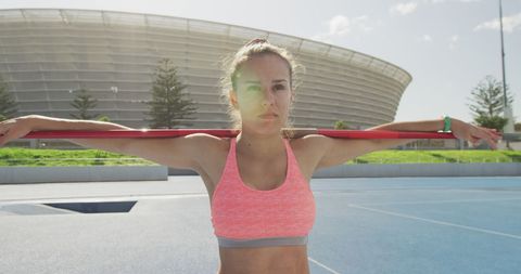 Confident female javelin thrower preparing on sunny field