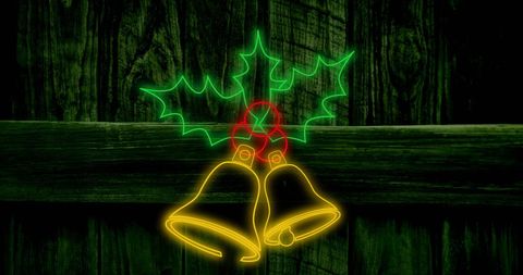 Festive neon christmas bells with holly on rustic wood