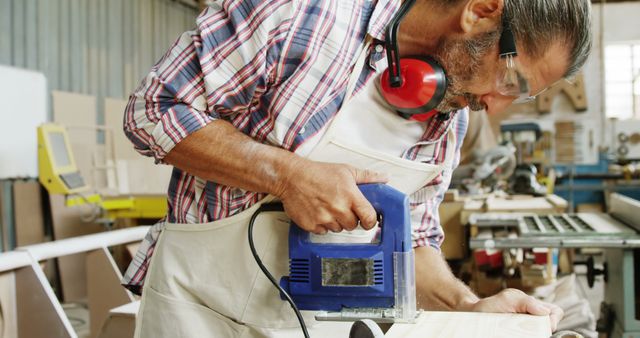 Carpenter Craftsman Cutting Wood Using Power Tool in Workshop - Download Free Stock Images Pikwizard.com