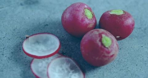 Closeup Magenta Radishes with Translucent Slices on Bluish Gray Stone Surface Macro Still Life