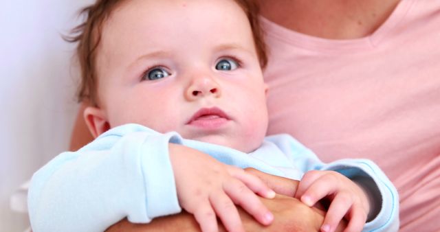 Close-Up of Baby in Mother's Arms with Blue Eyes and Light Skin - Download Free Stock Images Pikwizard.com