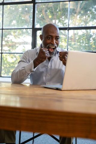 Triumphant Business Professional Celebrating Success at Laptop